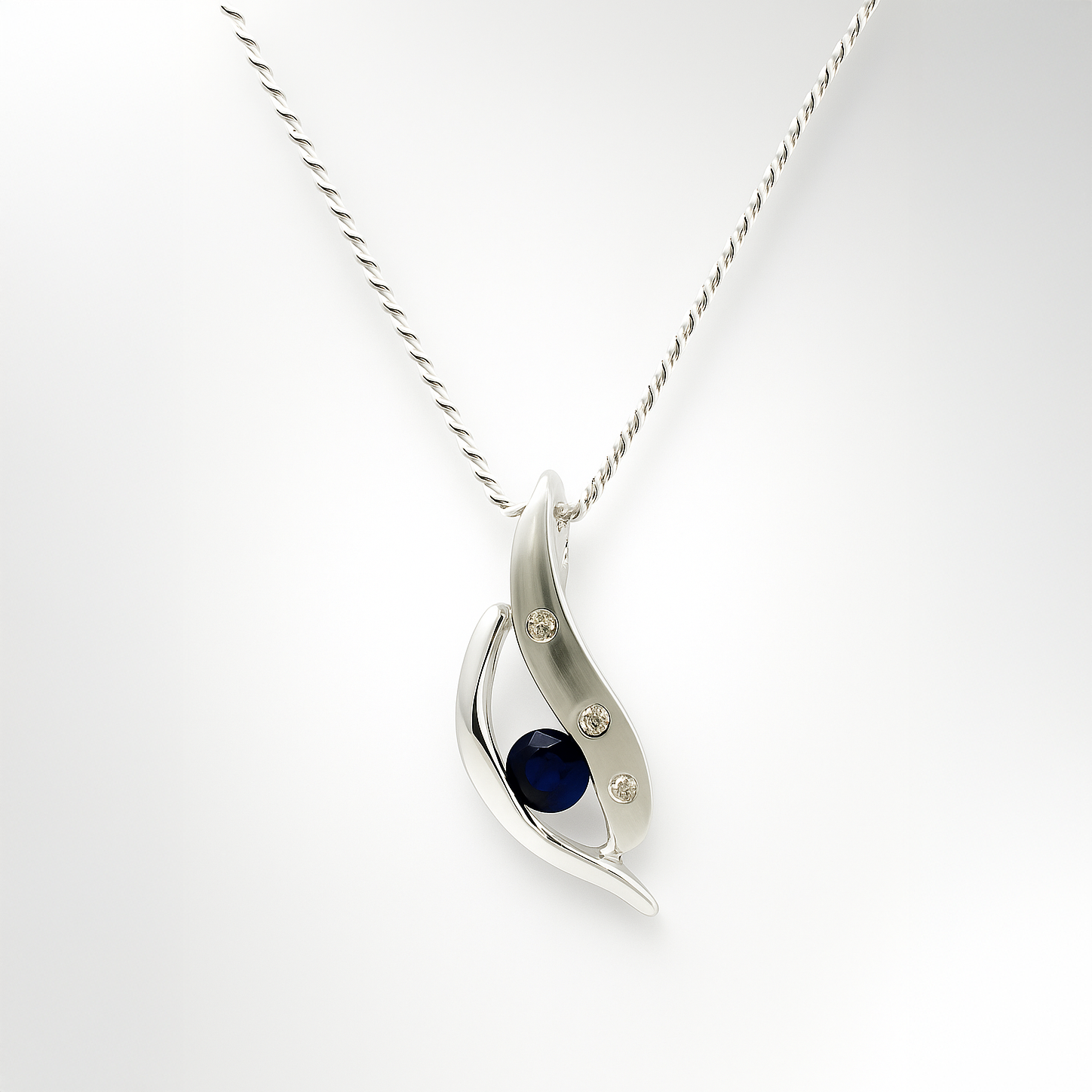 Silver pendant with sapphire and diamond on a white background