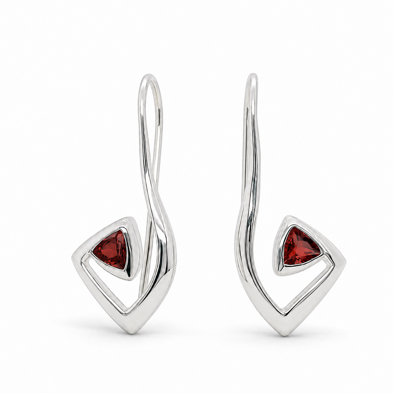 A pair of modern sterling silver dangle earrings with a twisted wire design and a small triangular red gemstone inset, shown on a clean white background.