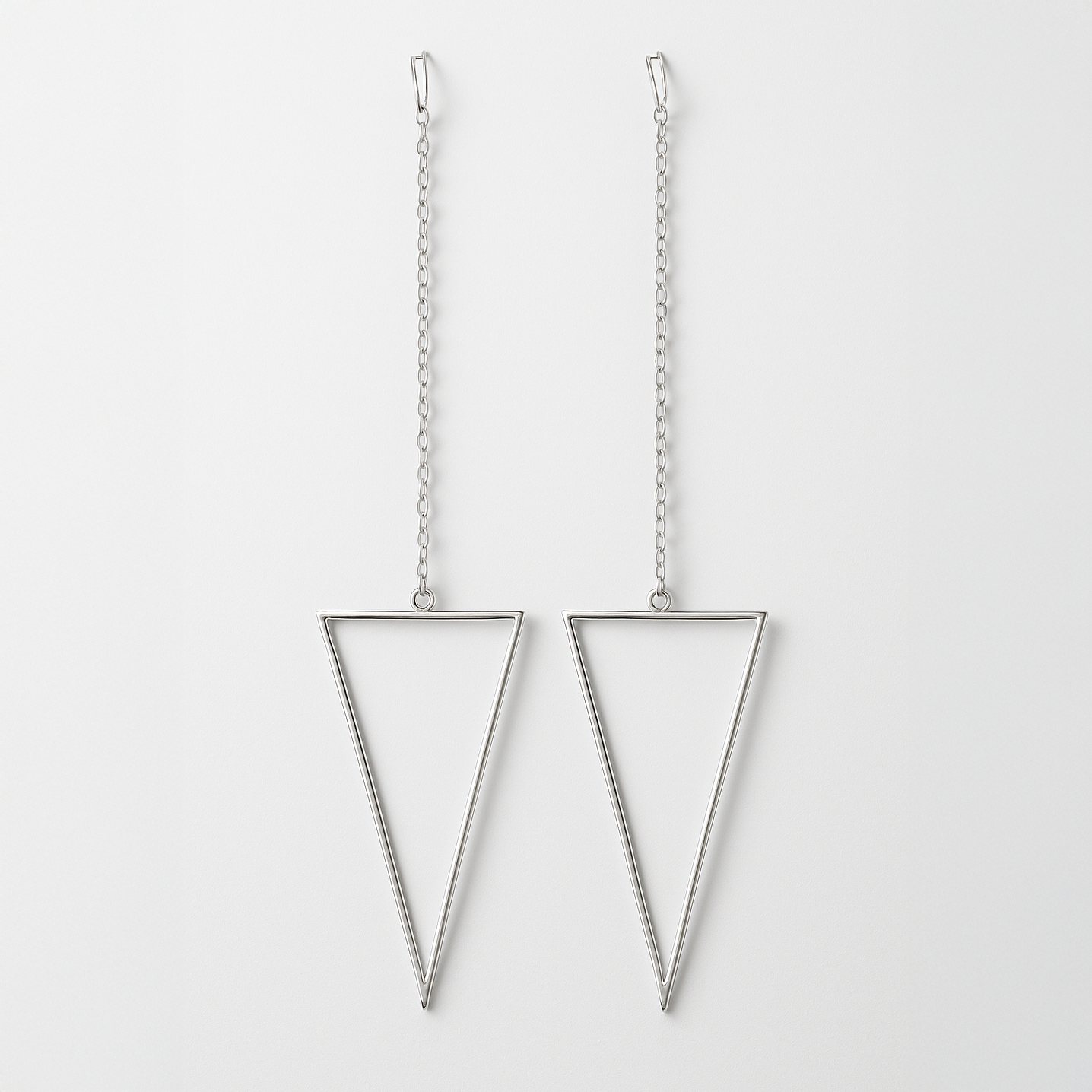 Pair of silver triangle earrings on a white background