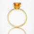 Gold ring with a citrine orange gemstone on a white background