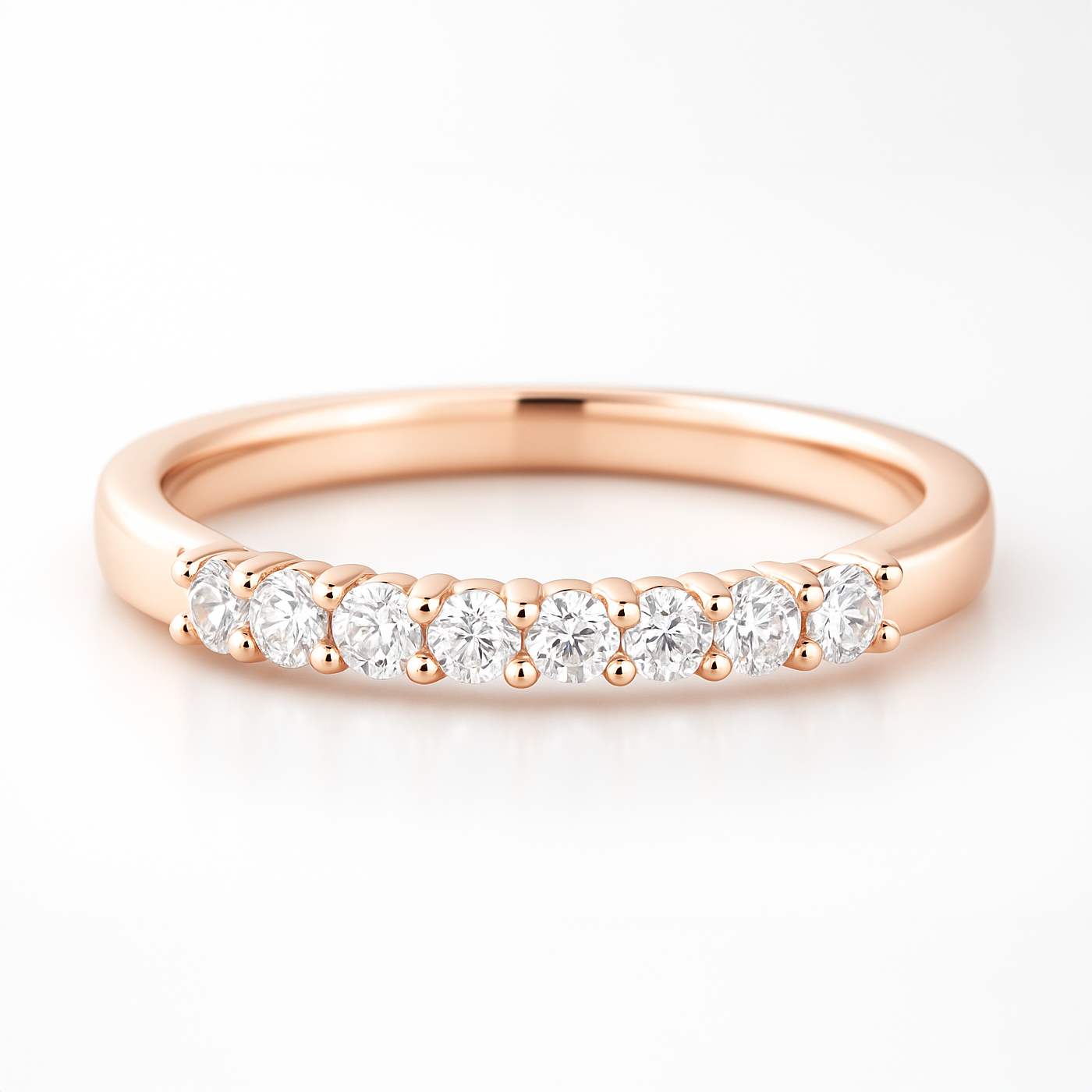 Rose gold wedding ring with diamonds on a white background