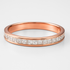 Rose gold ring with diamond stones on a light grey background