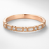 Rose gold ring with diamond accents on a light gray background