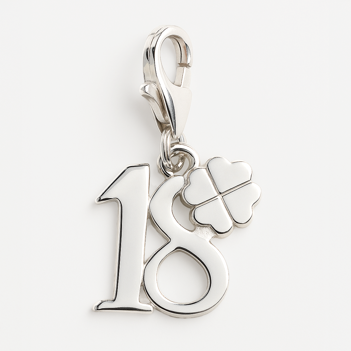 Silver charm with number 18 and clover leaf on a white background