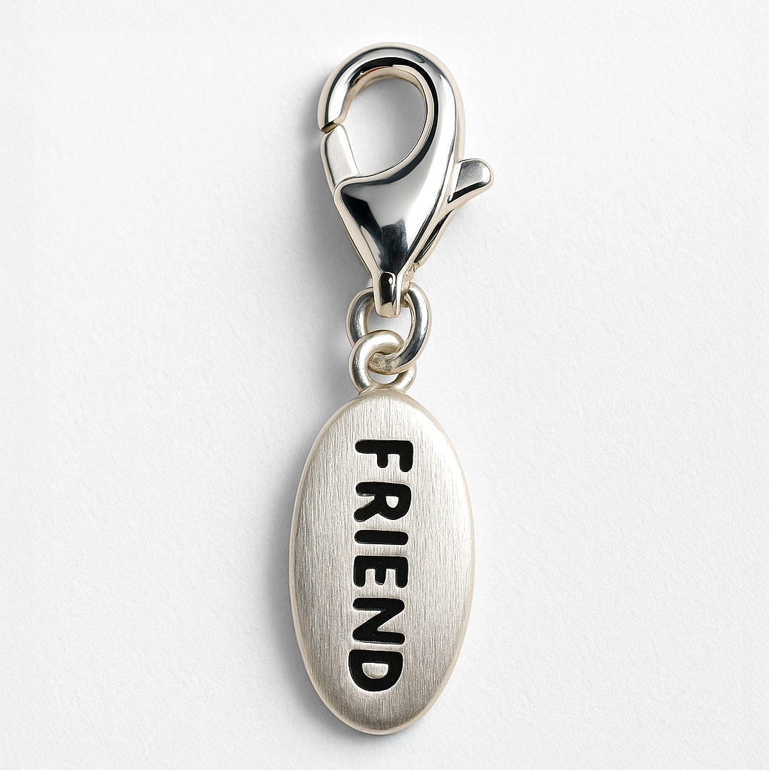 Silver charm with 'FRIEND' engraving on a white background