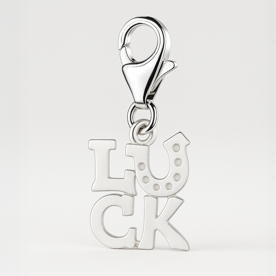 Silver 'LUCK' charm with a lobster clasp on a light gray background