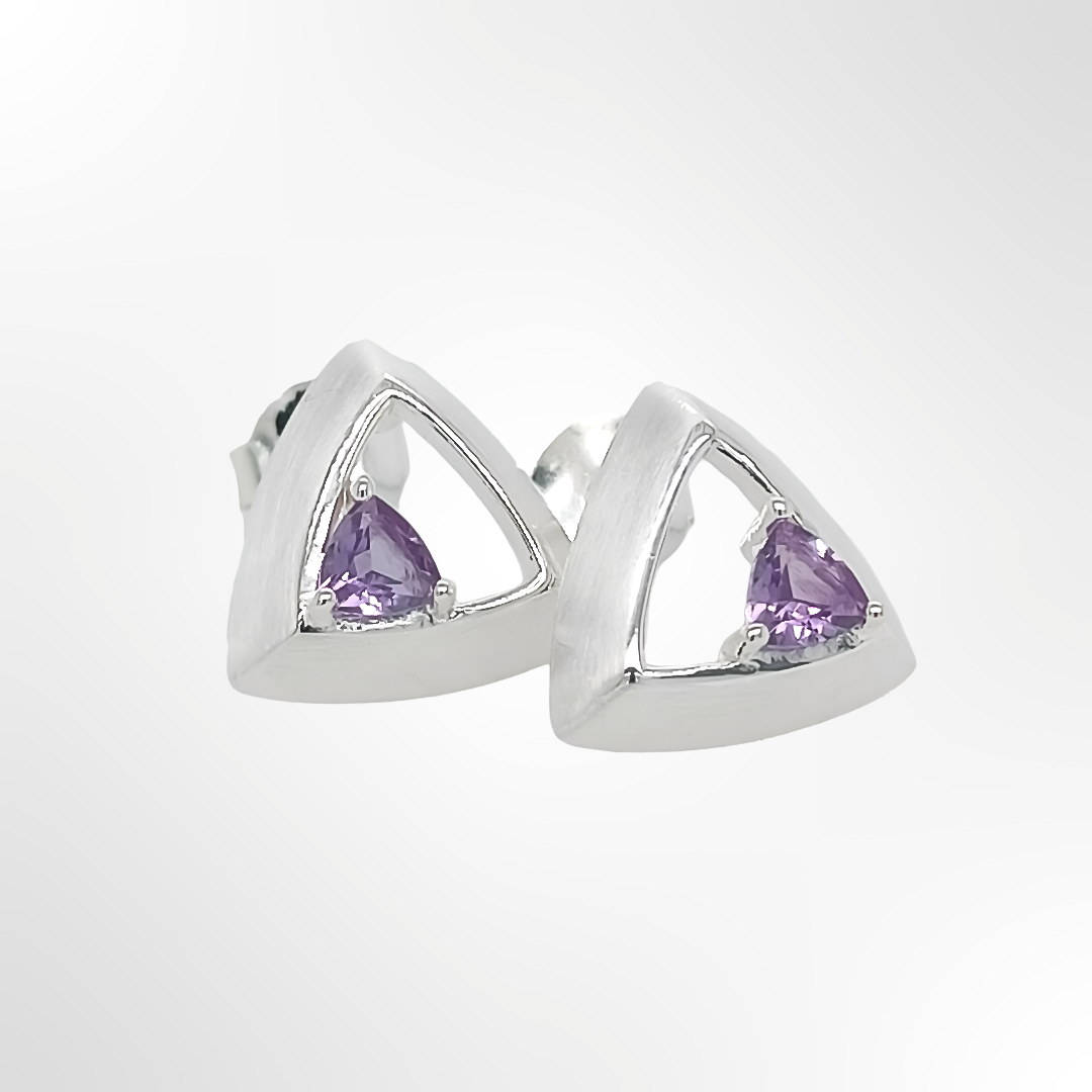 Pair of silver earrings with purple gemstones on a white background