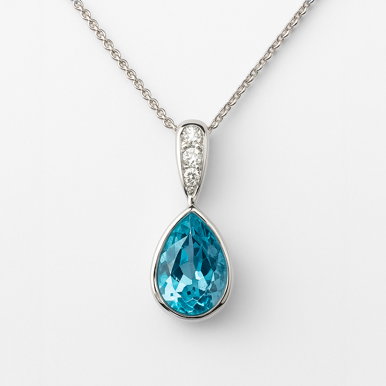 Teardrop-shaped blue gemstone pendant with cz accents on a white background