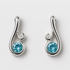 Pair of silver earrings with blue gemstones on a light grey background