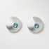 Pair of silver earrings with blue gemstones on a light gray background