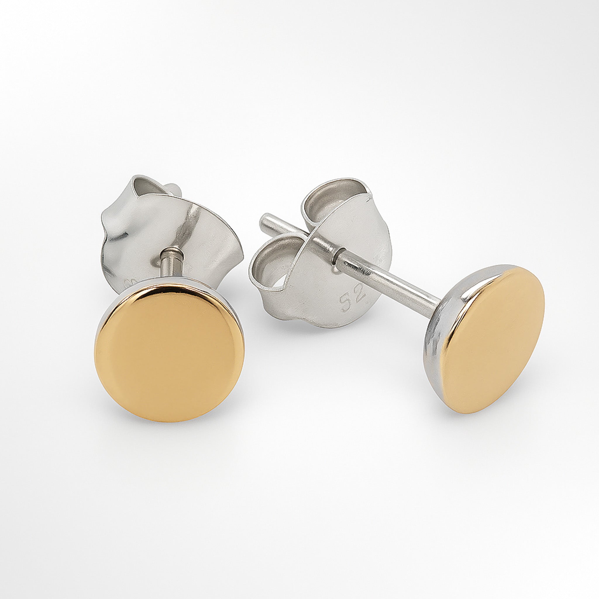 Gold and silver stud earrings on a white background