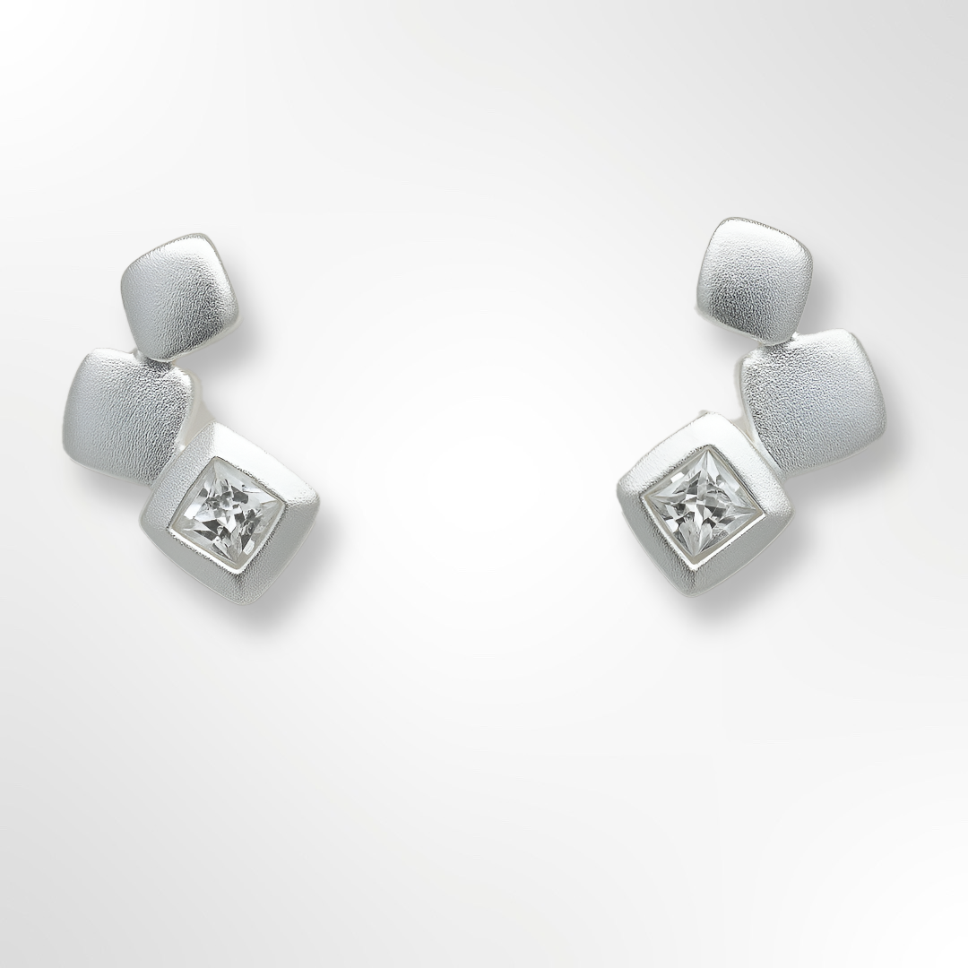 Pair of silver earrings with cubic zirconia on a white background