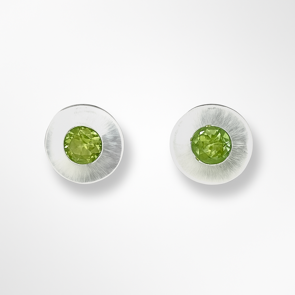 Pair of earrings with green gemstones on a white background