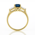 Gold ring with a blue gemstone on a white background