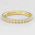 Gold ring with diamonds on a light gray background