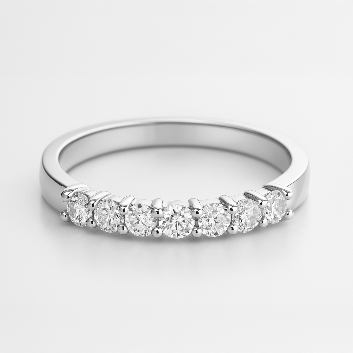 White gold wedding ring with small diamonds on a white background