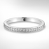 White gold wedding ring with small diamonds on a light grey background