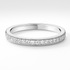 White gold wedding ring with small diamonds on a light grey background