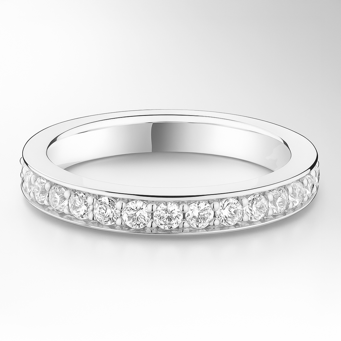 White gold wedding ring with small diamonds on a light grey background