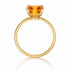 Gold ring with a large orange gemstone on a white background