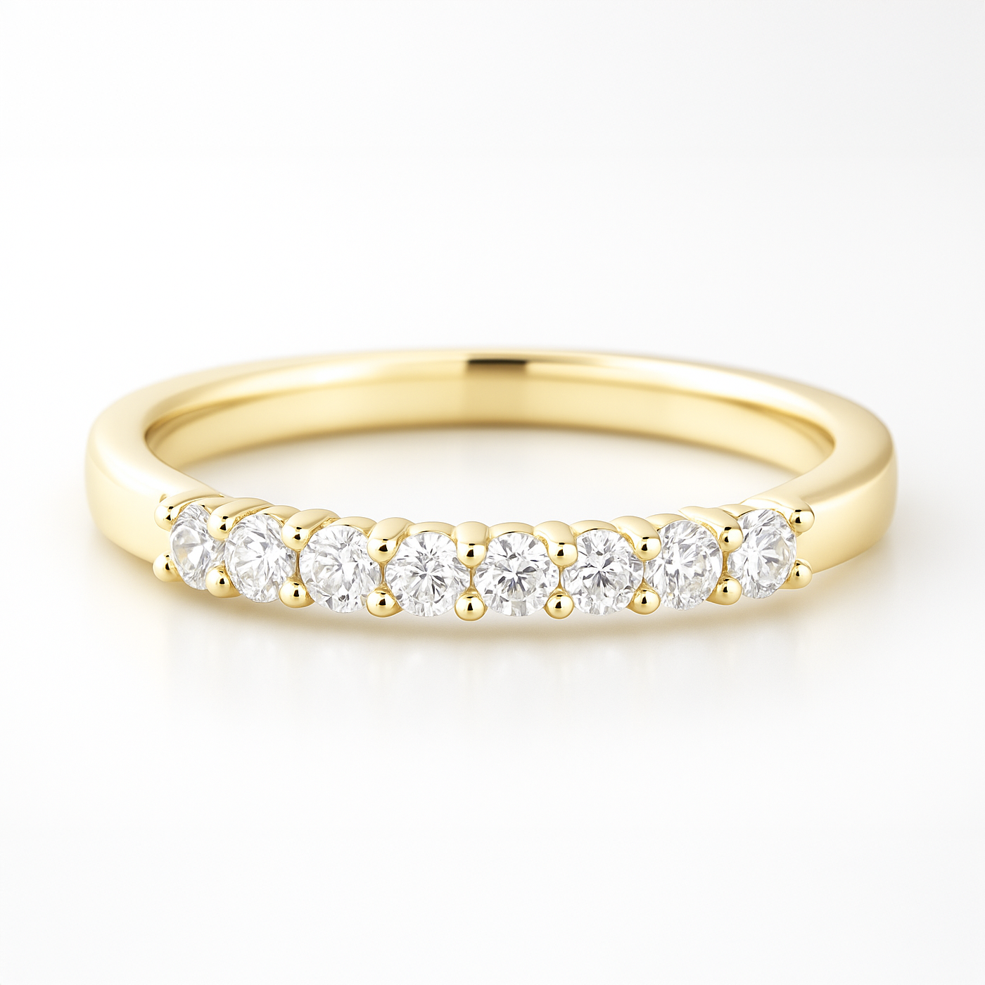 Gold wedding ring with small diamonds on a white background