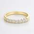Gold wedding ring with diamonds on a light grey background