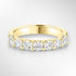 Gold wedding ring with diamonds on a light grey background