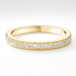 Gold wedding ring with small diamonds on a white background