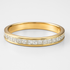 Gold ring with diamond stones on a light grey background